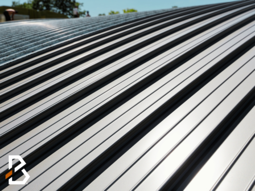 Close-up of an aluminum roof showing its reflective surface with the BELDON Roofing Company logo in the bottom left corner.
