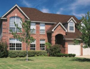 A large brick home with multiple windows and a well-manicured lawn