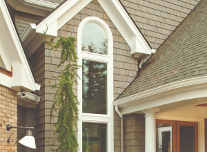 a specialty window on a tan house exterior